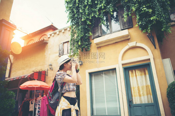 年轻时髦女人背包旅行在城市拍照图片