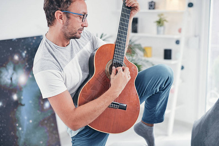 男人在客厅里弹吉他图片