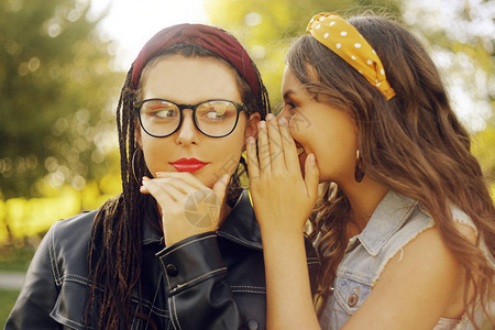 两个朋友分享秘密姐妹们八卦女孩在耳边语着一个秘密两个美丽图片