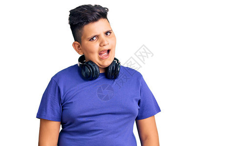 听音乐时戴耳机的小男孩用感的表情欢乐和快乐的面孔图片