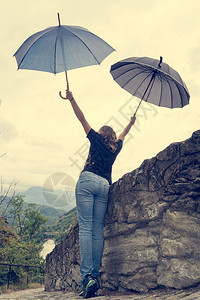 年轻女用雨伞在雨中跳舞千百年来在外图片