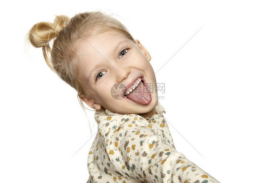 滑稽小女孩的肖像露出她的舌头在白色背景上与图片