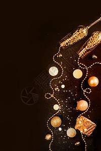 香槟杯上装满了金饰品在黑色闪发光的背景中庆祝最起码的圣诞晚会海报复图片
