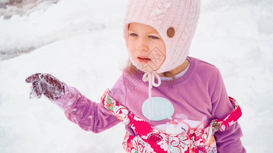 小女孩在她家附近的雪里玩耍图片