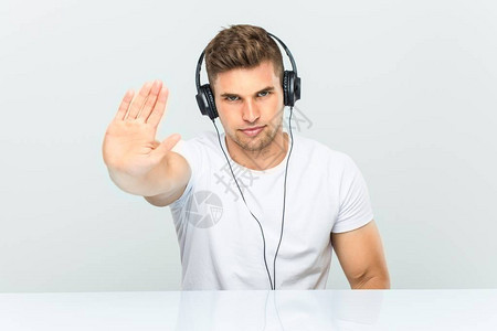 年轻人用耳机收听音乐用伸展的手举起手来显示停图片