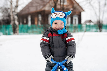 有趣可爱快乐男婴在雪背景外微笑图片