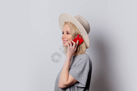 白色背景使用手机的金发女帽Blendewomani图片