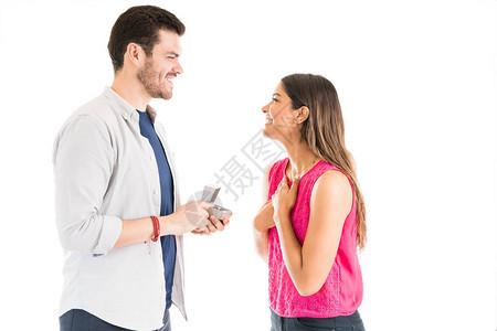 快乐的西班牙裔男友在工作室看着她时提出订婚戒指女友求婚图片