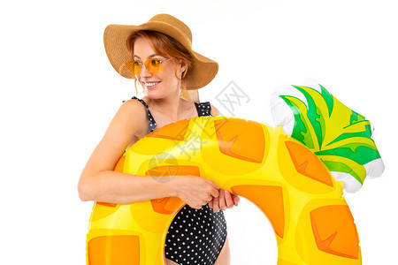 身着太阳镜和沙滩帽的年轻女子在白色背景下拿着救生圈图片