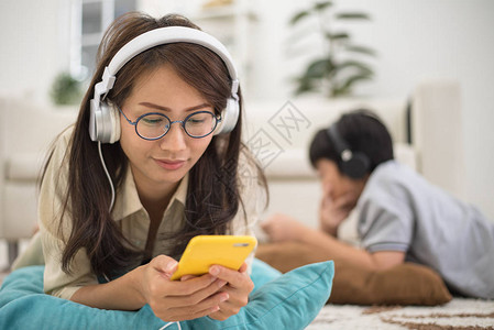 妇女在客厅用耳机放松和在地板上听音乐图片