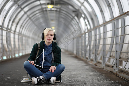 女孩坐在隧道里听音乐图片