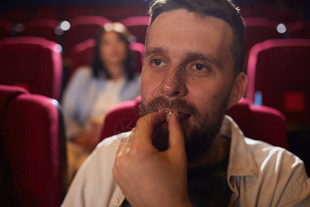 成人男子在电影中吃爆米花的同时图片