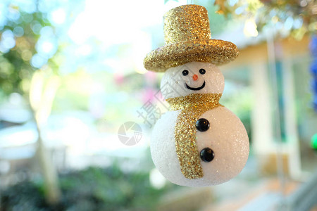 一个可爱的装饰雪人和一个可爱的金帽子在餐厅的玻璃窗图片