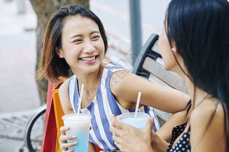 开心的亚洲女人喝着新鲜鸡尾酒图片