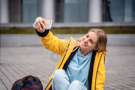 美丽的女孩用智能手机自拍图片