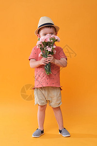 可爱的小男孩闻到了花的味道演播室在夏图片