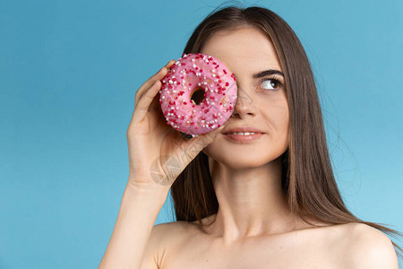 一个长头发的女人拿着甜圈的特写镜头图片