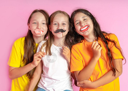 快乐的孩子们拿着假胡子和嘴唇图片
