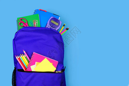紫色背包里满是学校用品图片