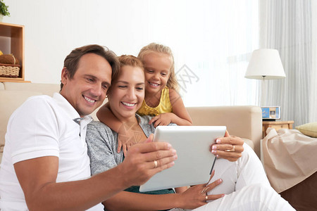 3个快乐的家庭一起看平板电图片