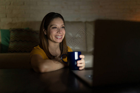 一个漂亮女人的肖像喜欢在她的笔记本电脑上看电视节目图片