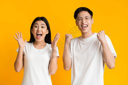 伟大的新闻情感型的亚裔夫妇表达幸福黄图片