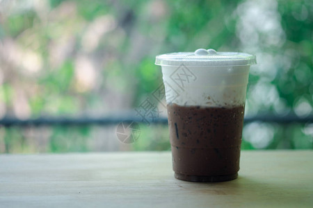 外卖玻璃杯中的冰摩卡咖啡和自然背景的牛奶泡沫显示层牛背景图片