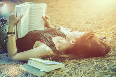 女人在公园里放松阅读假期在阅读中睡觉休息年轻女在假期放松睡觉读书自然图片