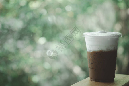 外卖玻璃杯中的冰摩卡咖啡和自然背景的牛奶泡沫显示层牛图片
