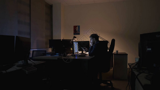 年轻工人正坐在办公室的电话上影视素材员工在办公室里坐在电脑前图片