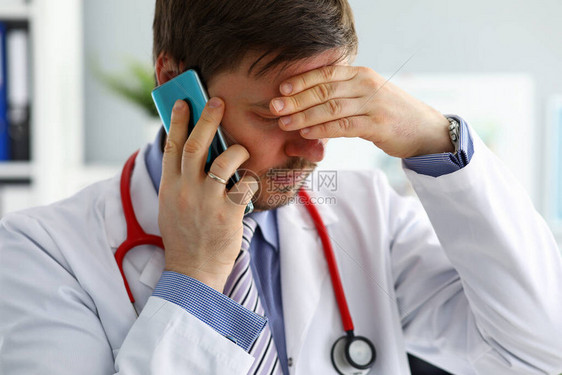 焦虑的医生通过电话听取投诉预防心脏病方便与医生和选择专家预约帮助选择有图片
