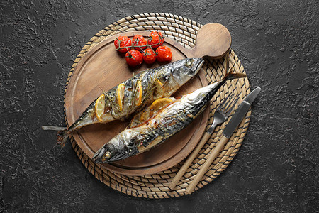 深色背景中烤鲭鱼的木板背景图片