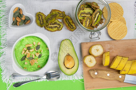 牛油果和猕猴桃凝乳健康饮食概念各种样的产品在绿背景图片