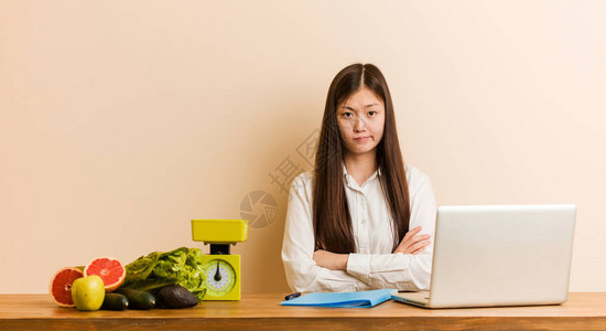 带着笔记本电脑工作的年轻营养主义者女人不开心地用讽刺的表图片