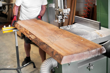 木工在木工车间用带锯切割一块大木板图片