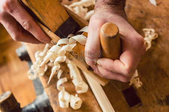 与木材规划师手和工具一起工作的木匠大图片