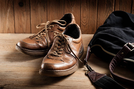 木质背景中男士旧棕色皮鞋图片