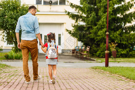 父亲在小学一年级时率领一个小女孩学生上学图片