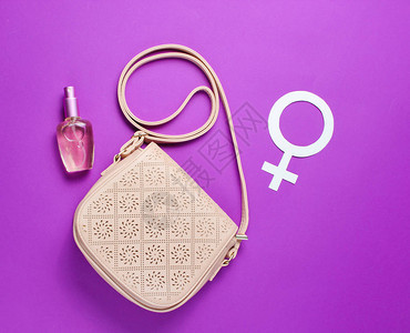 女时装袋香水瓶紫色背景上的别女权主义符图片