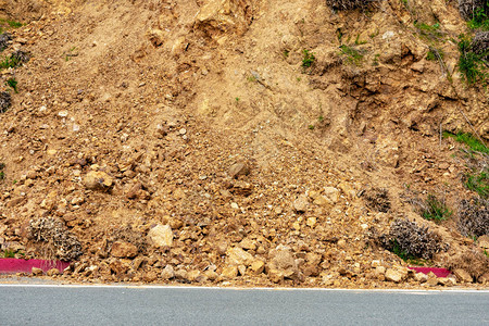 冬季暴雨后陡坡上农村道路上的山体滑坡碎片散落的滑坡碎片覆盖了高速公路图片