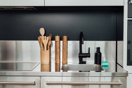 厨房中靠近水龙头水槽肥皂撒布机和海绵的木制胡背景图片