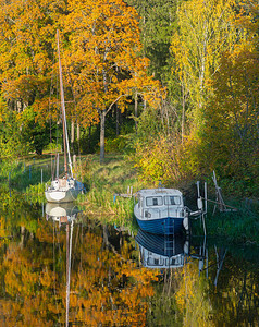 在美丽的秋天风景中停泊在运河中的船图片
