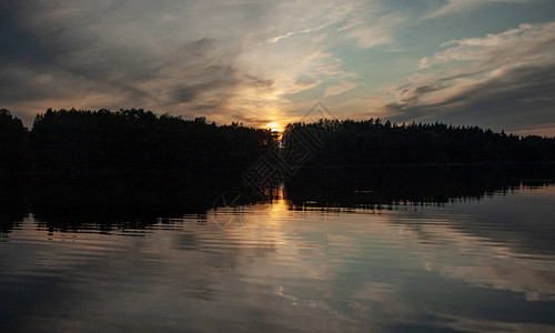 湖上的日落美丽的颜色混乱的云强光黑森林剪影拉脱维图片