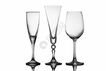 三个优雅的玻璃杯不同的形状红酒杯和香槟笛子在反射白图片
