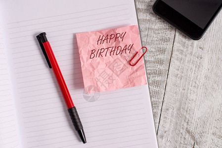 概念手写显示生日快乐概念意义展示的生日纪念日是用礼物皱纹纸笔记本和放在木制背景上的图片