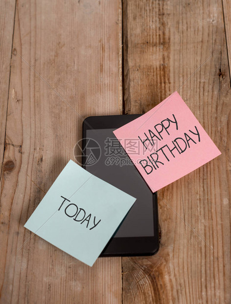 手写文本生日快乐概念照片一场展示的诞生周年纪念日是用礼物智能手机庆祝的图片