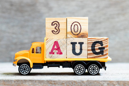 卡车在木材背景上持有30aug字的母块日期为图片
