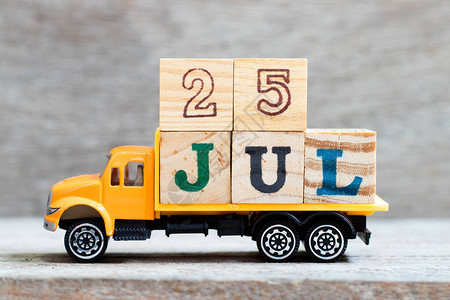 卡车在木材背景上持有25jul字的母块7月图片