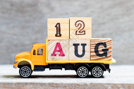 卡车在木材背景上持有12aug字的母块规定日期为图片