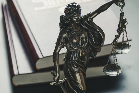 法庭上拿着天平和高角度反对法律的正义人物雕背景图片
